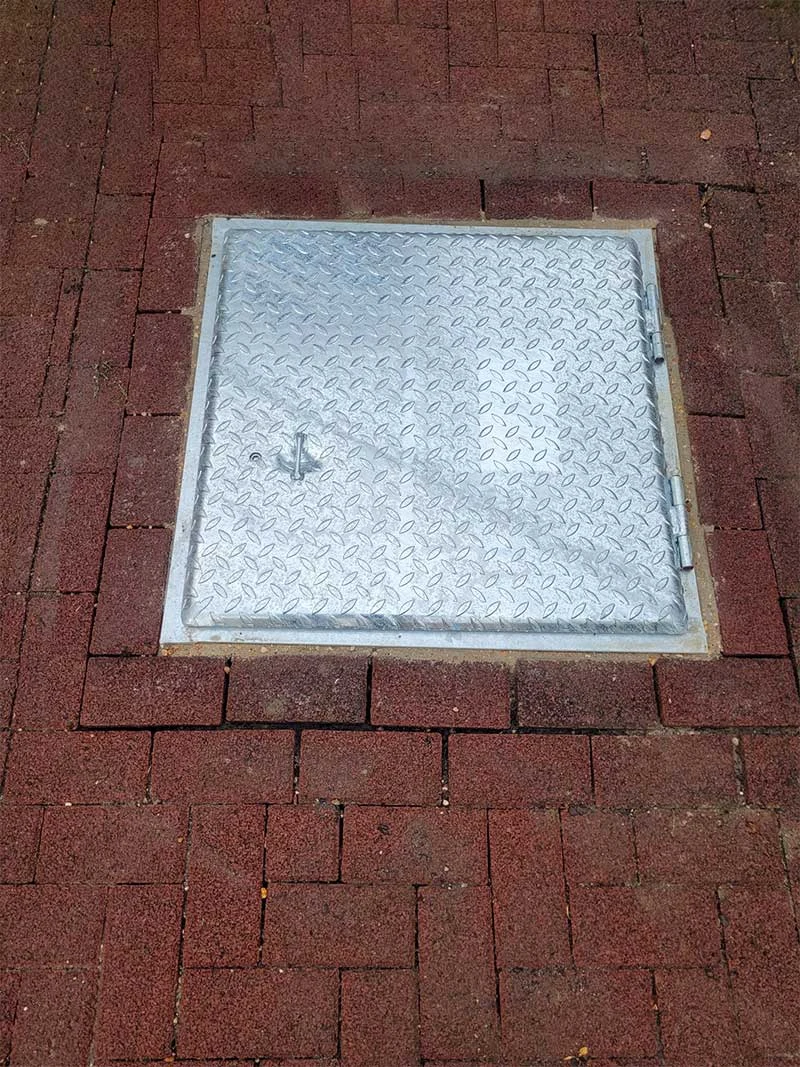 Schachtabdeckung in einer Hofeinfahrt.
